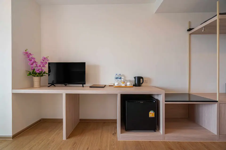 Skrivebord med tv, minibar og kaffefaciliteter i et standardværelse på Orchidacea Resort