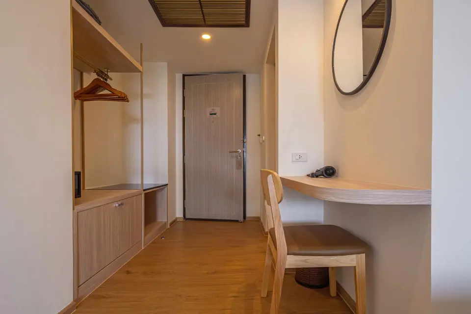 Garderobe, skrivebord og indgangsdør i et værelse på Orchidacea Resort