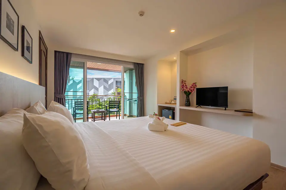 Superiorværelse med bred dobbeltseng og åben altandør på Orchidacea Resort