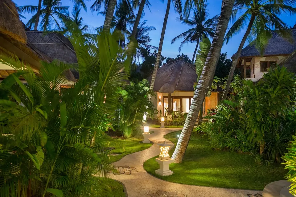 Oplyst havesti mellem bungalows om aftenen