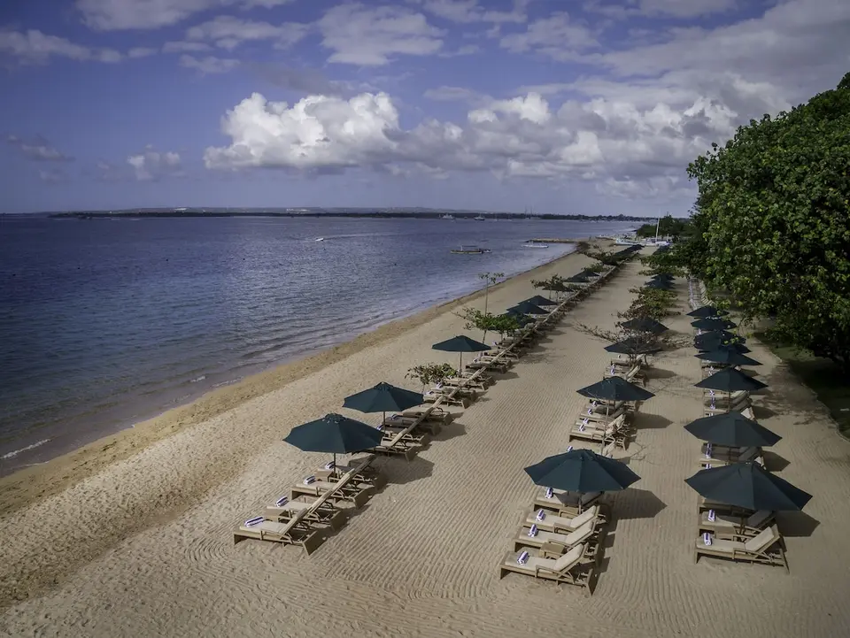 Liggestole og parasoller langs sandstranden