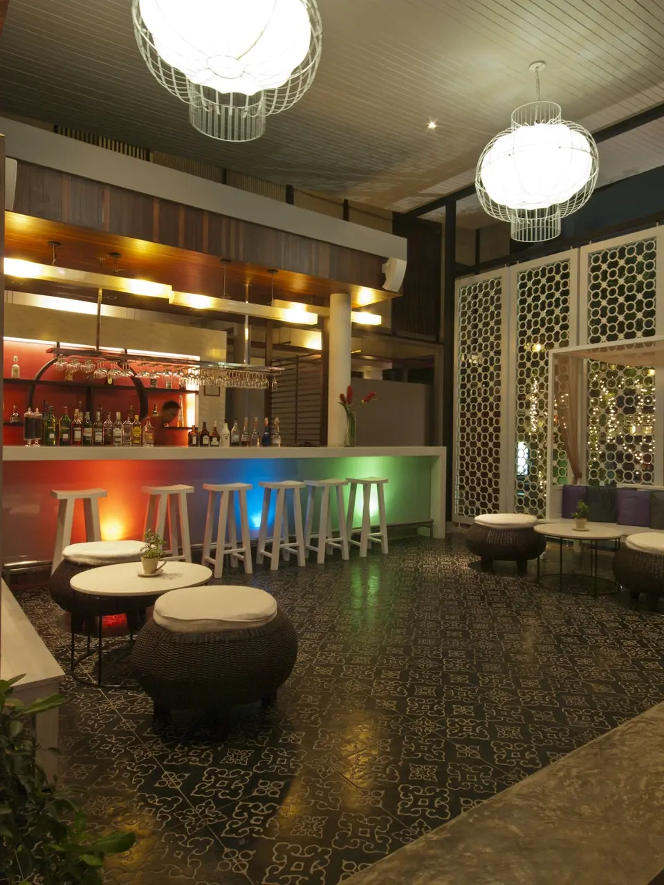 Bar med høje stole og små siddegrupper på Red Ginger Chic Resort