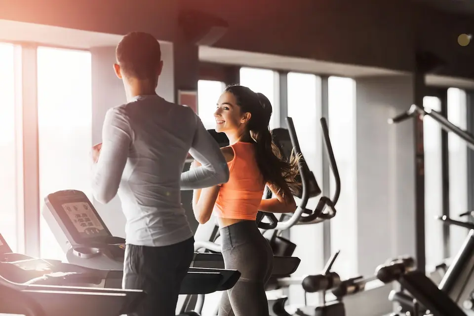 To personer træner ved løbebånd i fitnessrummet på SAii Koh Samui Villas.