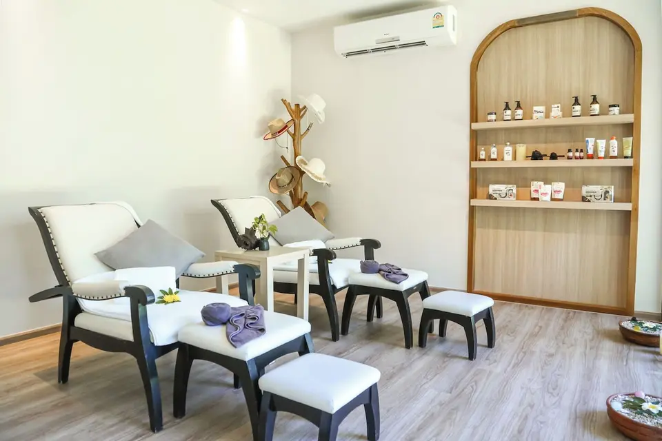 Spalokale med to lænestole, fodskamler og hylde med produkter på SAii Koh Samui Villas.