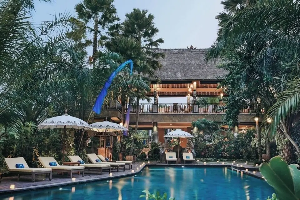 Fællespool med liggestole, parasoller og restaurantbygning hos The Sankara Resort & Spa.