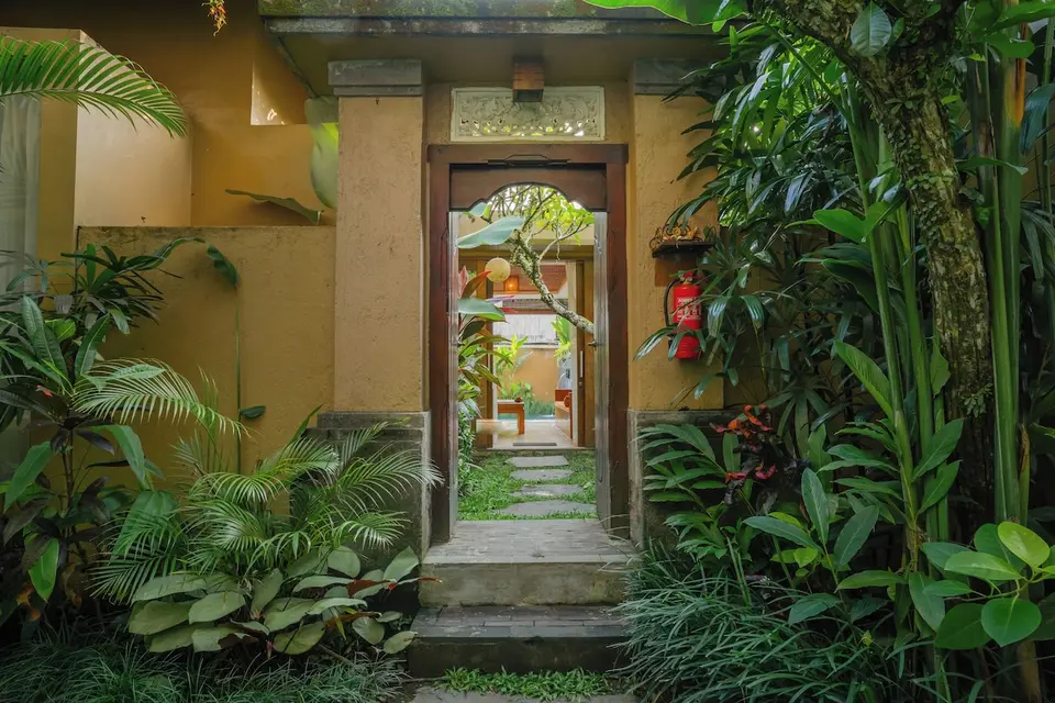 Indgang til en villa mellem grønne planter hos The Sankara Resort & Spa.