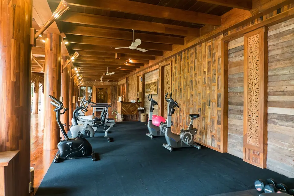 Santhiya Koh Phangan: Fitnessrum med motionscykler, løbebånd og træpaneler.