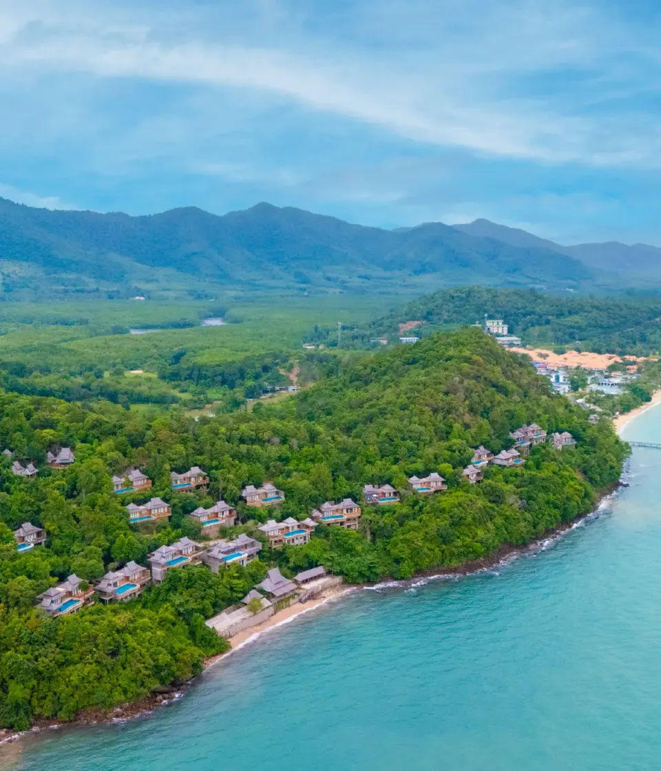 Luftfoto over Santhiya Koh Yao Yai med villaer på de grønne skrænter og bugten foran