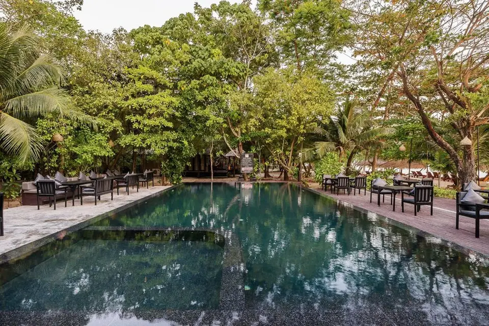 The Sevenseas Resort Koh Kradan: Rektangulær pool omgivet af træer, trædæk og siddepladser.