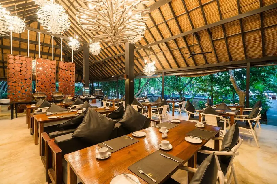 The Sevenseas Resort Koh Kradan: Restaurant med dækkede træborde, polstrede stole og højt stråtag.