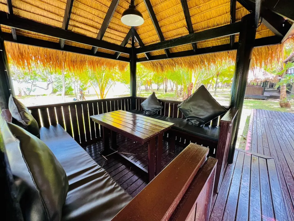 The Sevenseas Resort Koh Kradan: Overdækket terrasse med polstrede bænke og træbord.
