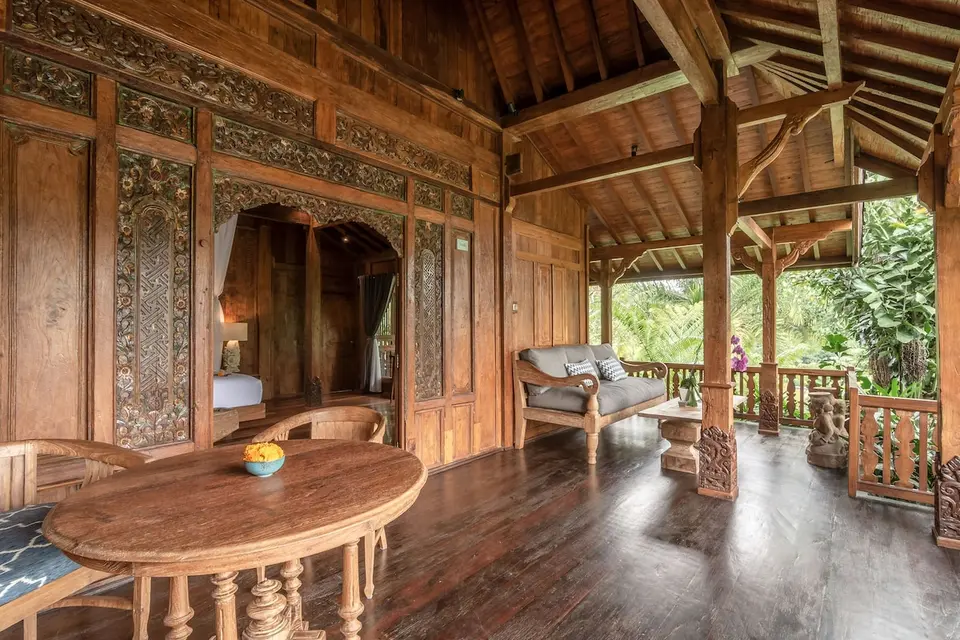 Overdækket veranda med udskårne træpaneler og siddepladser på Ubud Valley Boutique Resort