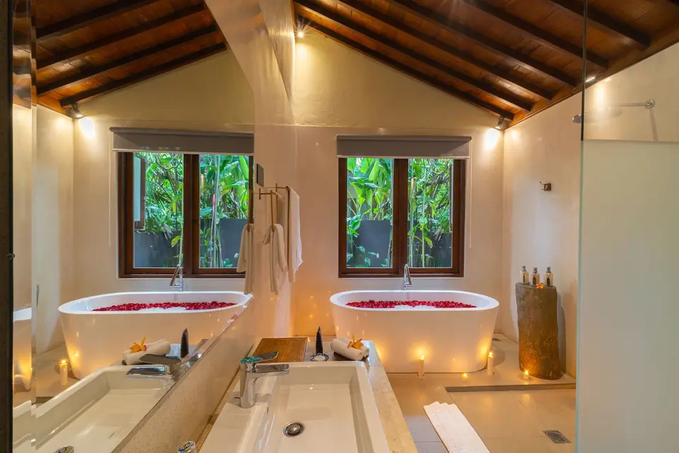 Badeværelse med badekar, stort spejl og træloft på Ubud Valley Boutique Resort