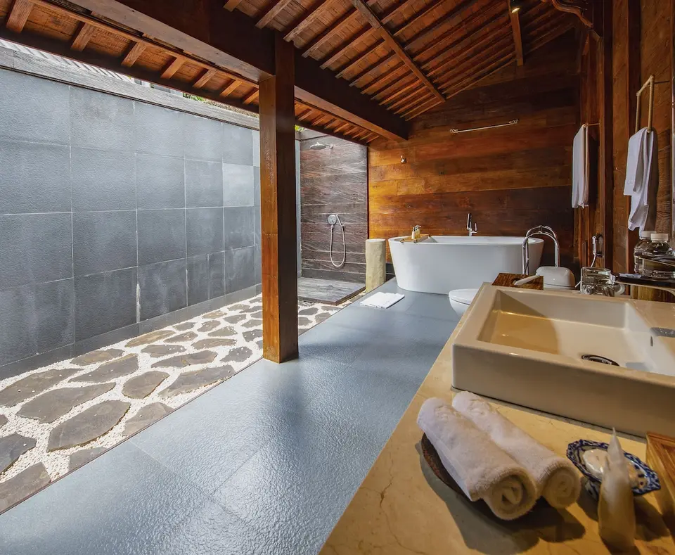 Delvist åbent badeværelse med bruser og badekar på Ubud Valley Boutique Resort
