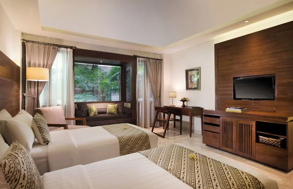 Værelse med to senge og siddeplads ved vinduet på Ubud Village Hotel