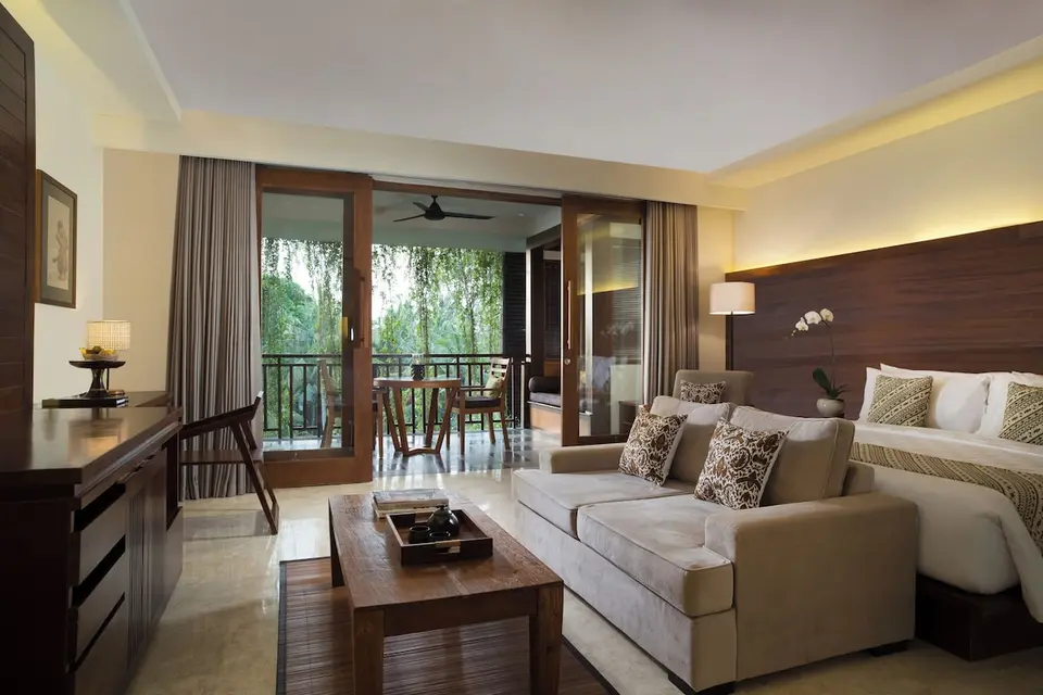Værelse med dobbeltseng, sofa og balkon på Ubud Village Hotel