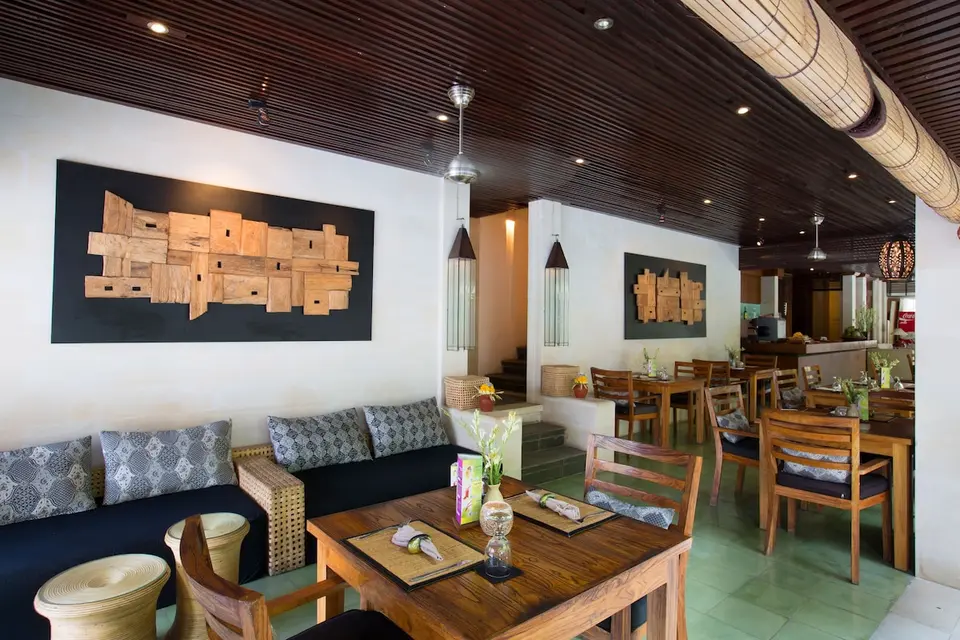 Spiseområde med bænk og trædekorationer på Ubud Village Hotel