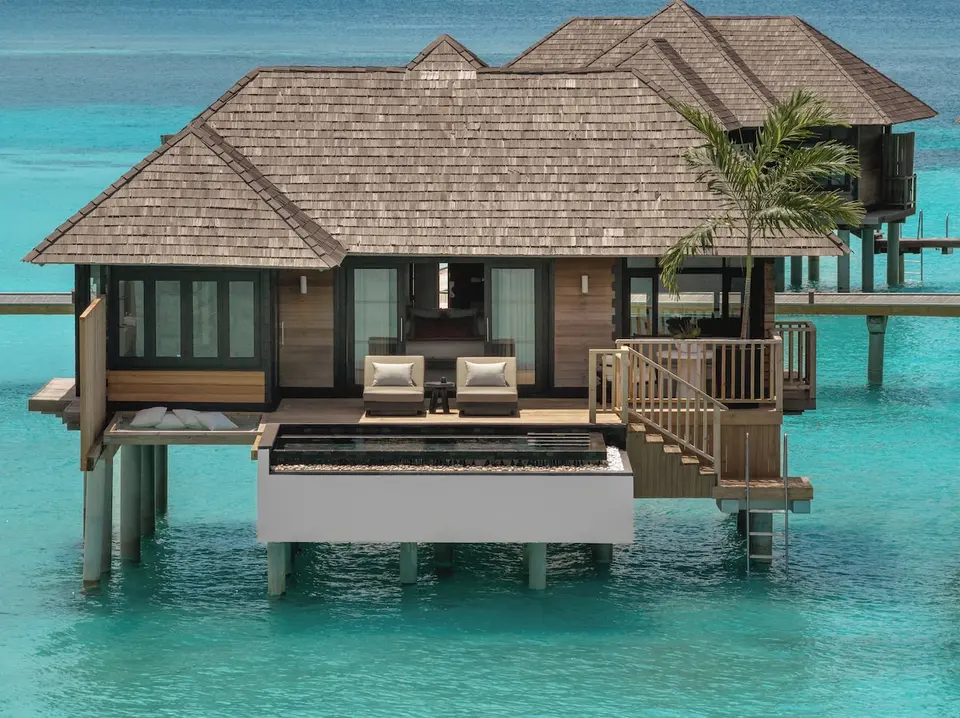Vandvilla med pool, liggestole og trappe til lagunen på Sun Siyam Iru Fushi