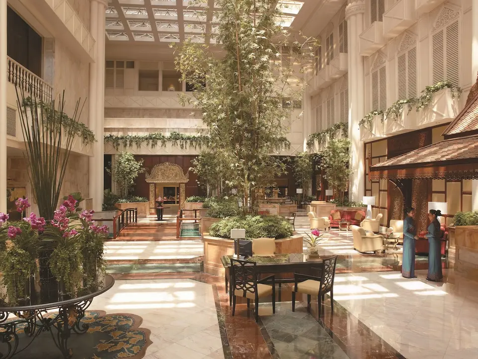 Indgang til Shangri-La Hotel i Bangkok med frodige planter og smuk indretning
