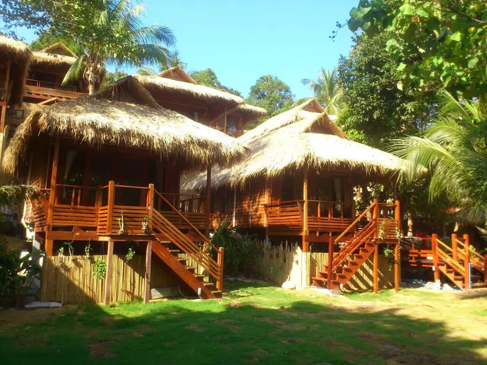 Bungalows i flere niveauer med trætrapper og terrasser på Ten Moons Lipe Beach Resort.