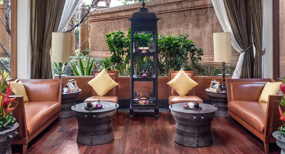 Indretning af stue på Hua Hin Resort & Spa med sofaer, borde og potteplanter
