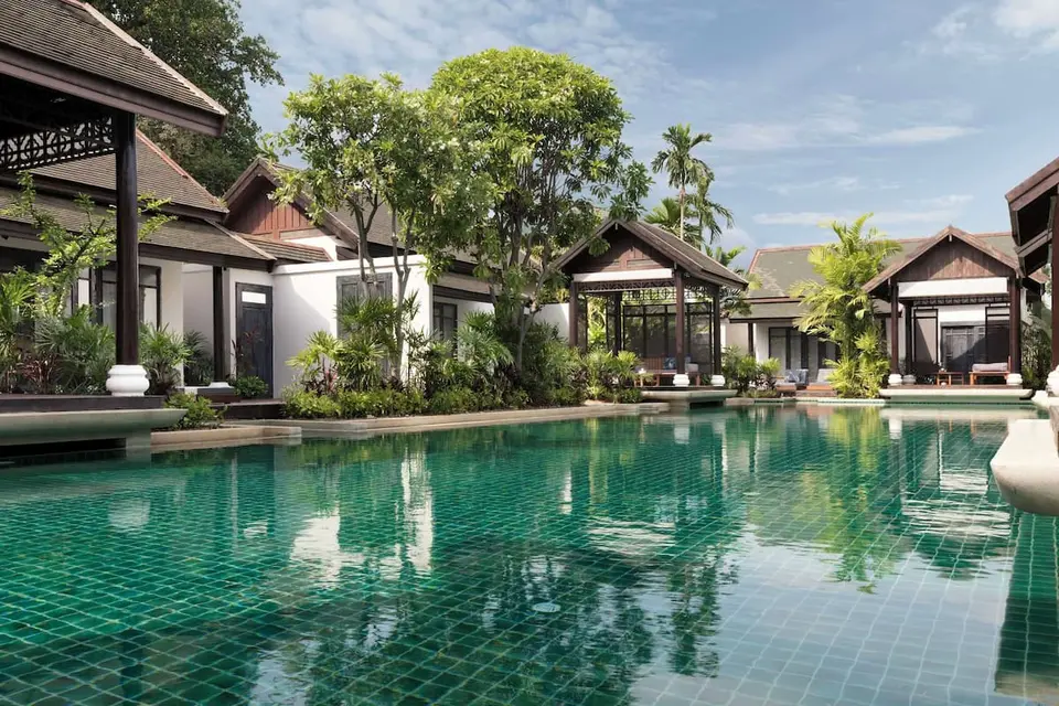 Lawana Samui Resort swimmingpool omgivet af tropiske træer og afslappende liggestole.