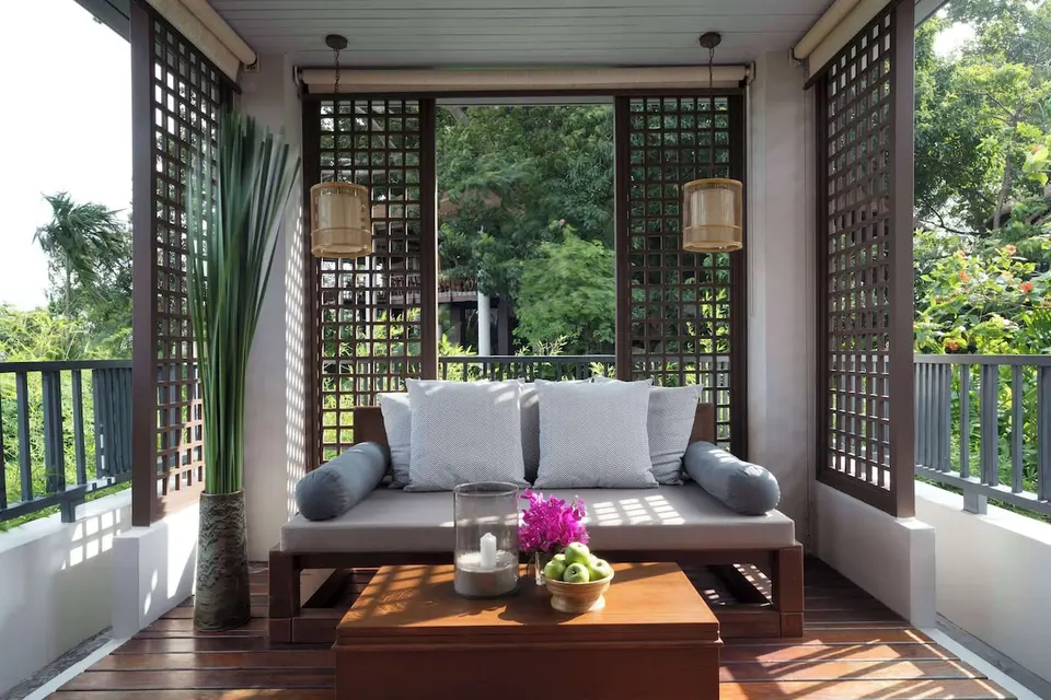 Træveranda med sofa og bord på Anantara Lawana Samui Resort