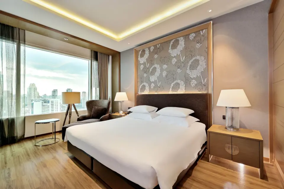Stort seng i Sathorn hotelværelse med byudsigt