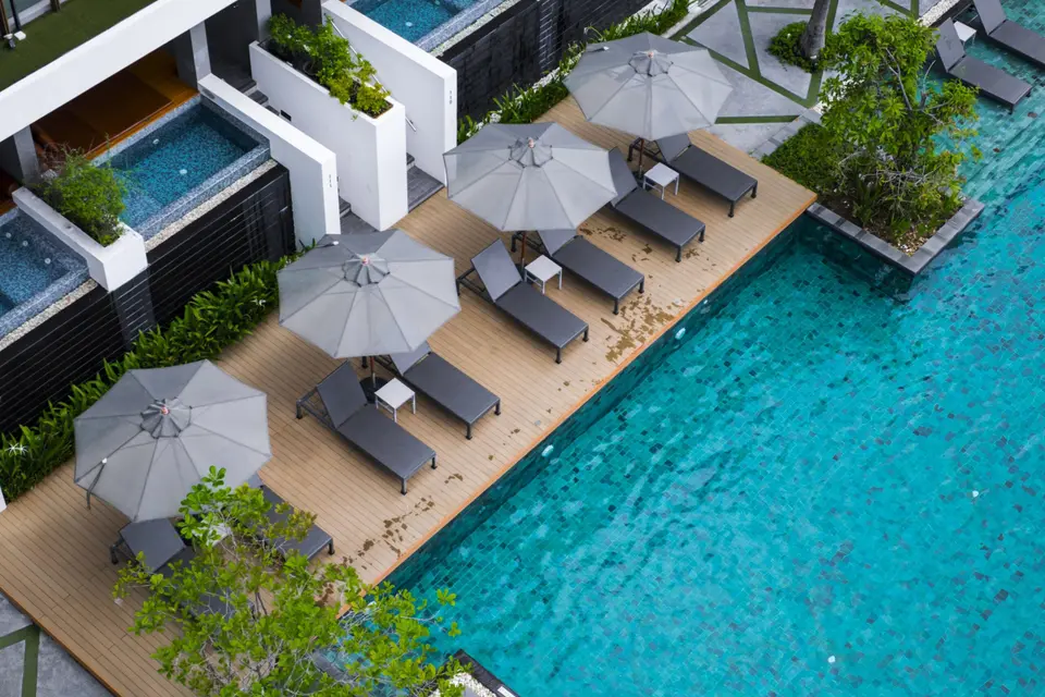 Pool og solterrasse set oppefra med små bassiner ved værelserne.