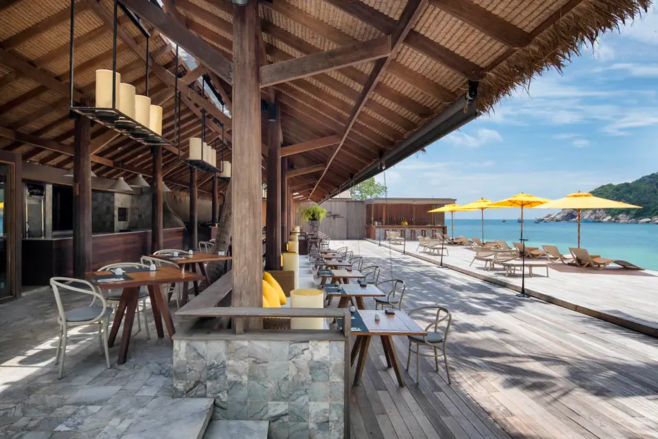 Haad Tien Beach Resort med træterrasse, borde og parasoller med udsigt til havet