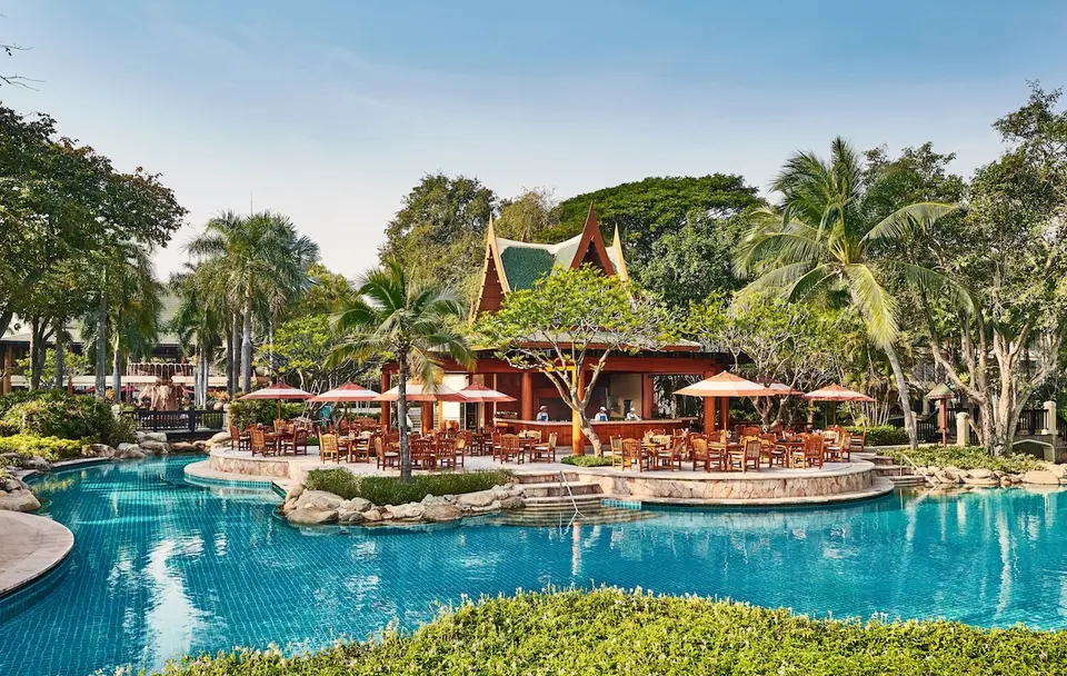 Hyatt Regency Hua Hin med fredfyldt poolområde, frodige træer og behagelige liggestole
