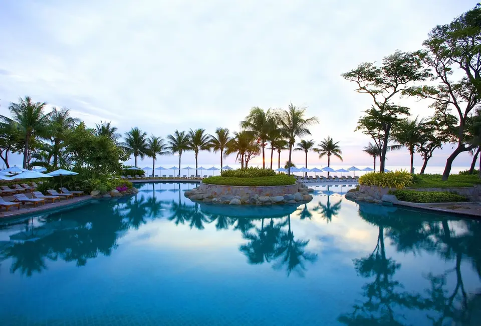 Hua Hin Hyatt Regency swimmingpool under palmer i skumringen