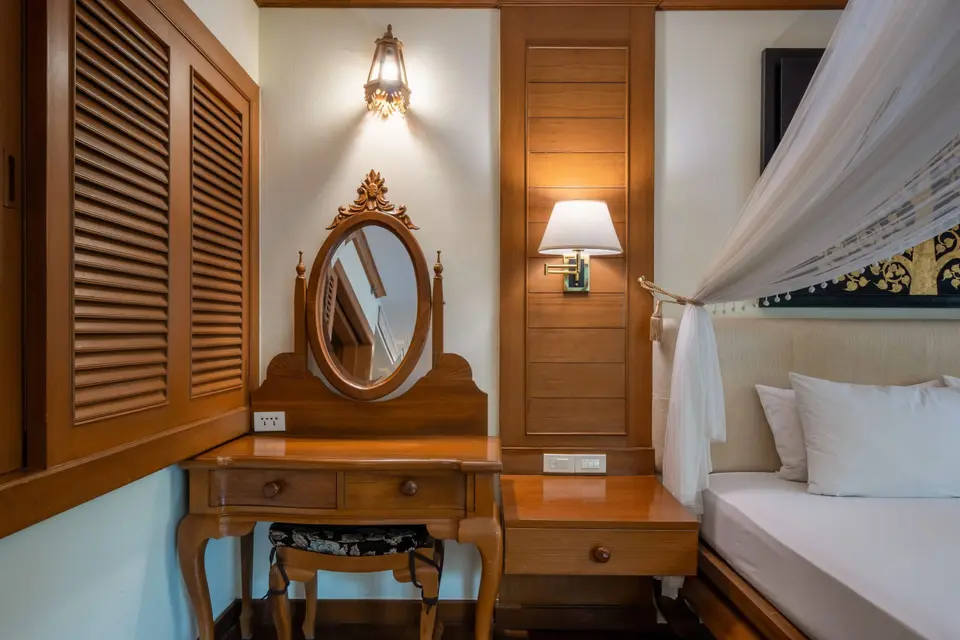 Khum Phaya Resort soveværelse med komfortabel seng, spejl og kommode