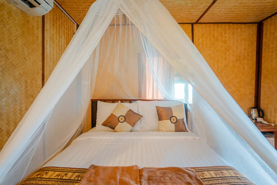 Komfortabel seng i elegant værelse på Koh Jum Resort med myggenet