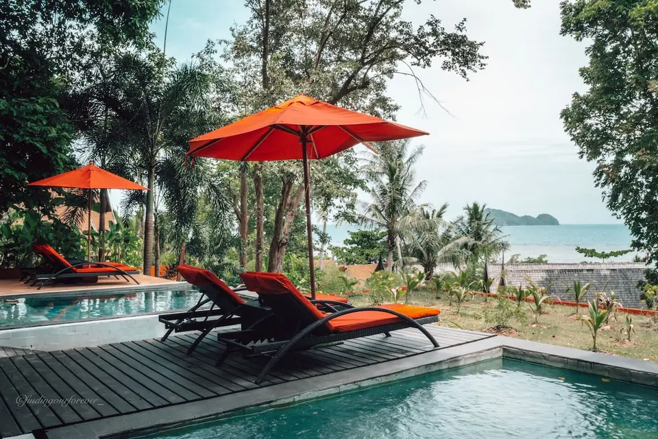 Pool med lounge-stole og havudsigt på Kupu Kupu Phangan Beach Villas