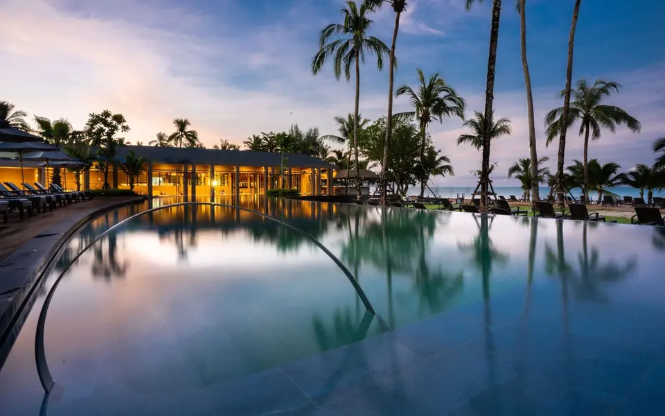 Swimmingpool omgivet af palmer på La Flora Resort Khao Lak