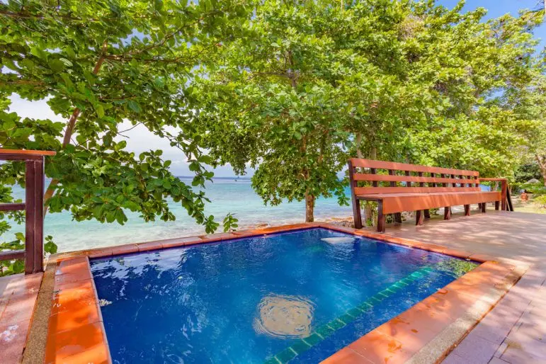 Lille pool og terrasse med bænk ved havet på Phi Phi Natural Resort.