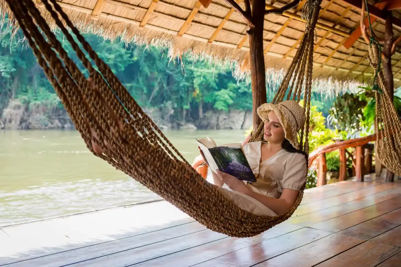 Kvinde læser en bog i hængekøje ved Jungle Rafts, River Kwai
