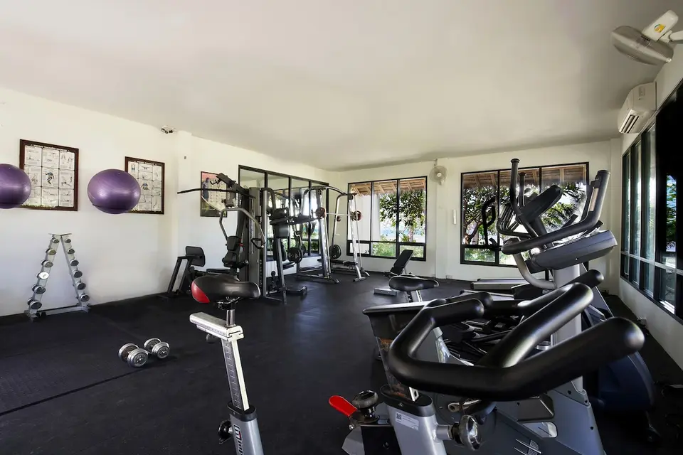 Fitnessrum med motionscykler, vægte og træningsmaskiner på Saii Phi Phi Island Village Beach Resort.