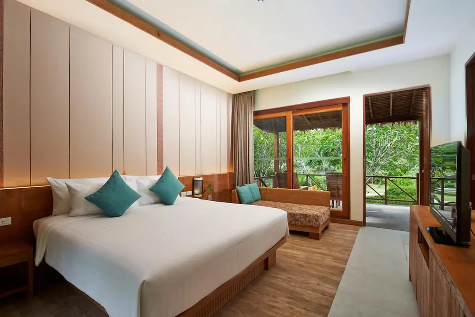 Værelse med dobbeltseng, sofa og balkon mod haven på Saii Phi Phi Island Village Beach Resort.