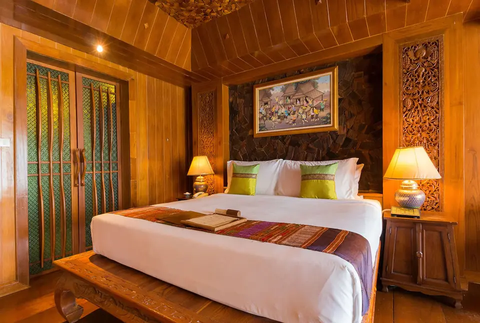 Santhiya Resort Koh Phangan værelse med træpaneler og seng