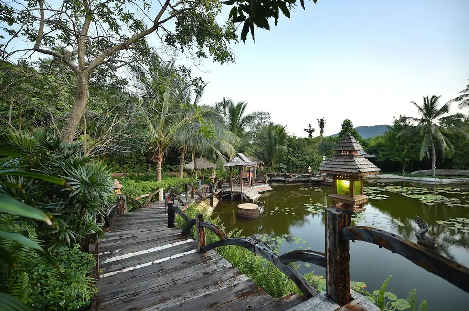 Træ gangbro ledende til en dam på Santhiya Resort Koh Phangan