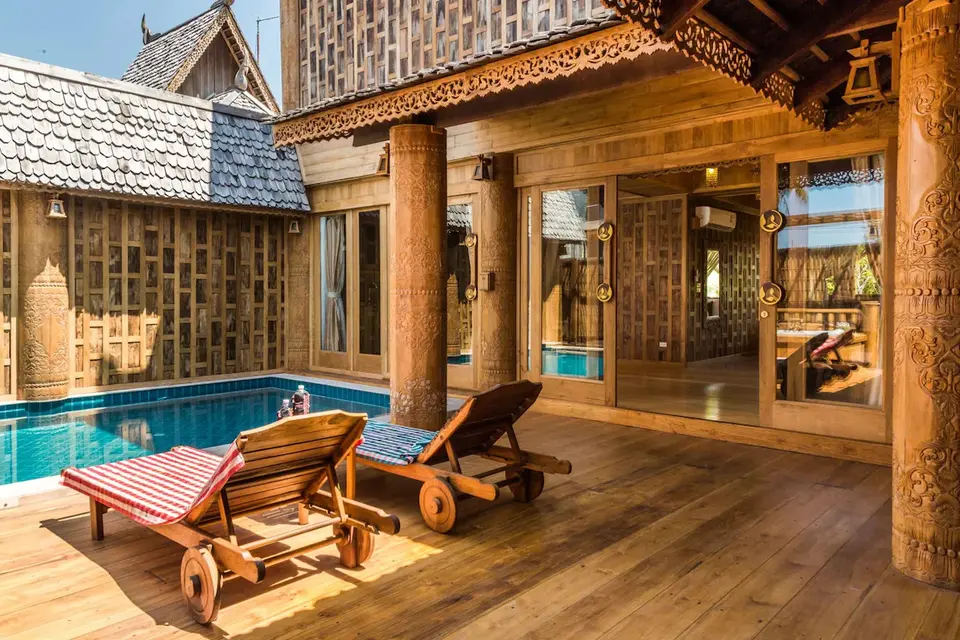 Træhus med swimmingpool og liggestole på Santhiya Phuket Natai Resort