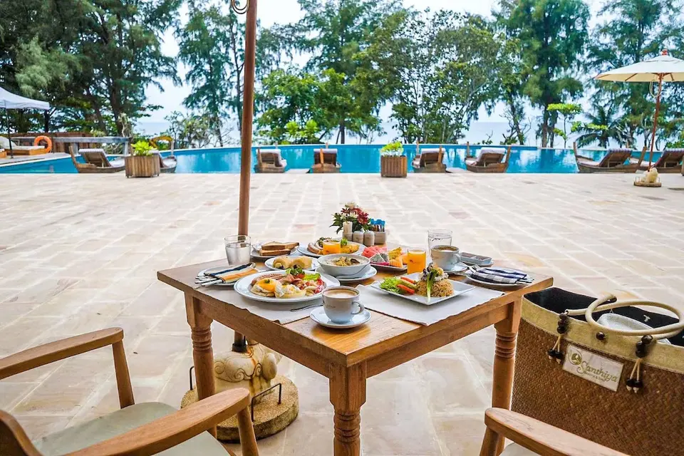 Santhiya bord med stole og Natai bord ved poolkant