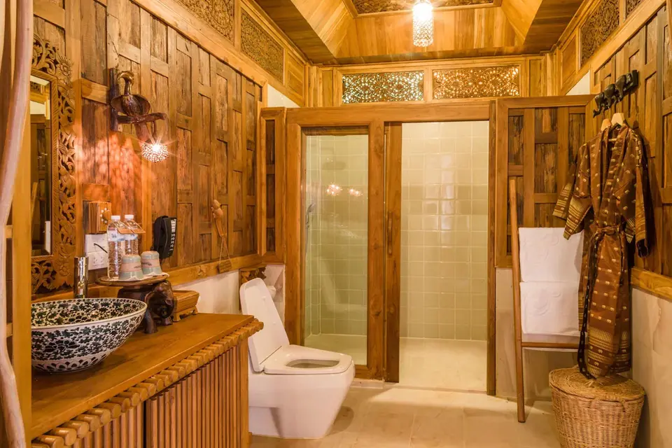 Billeder af badeværelse med træbeklædning og toilet på Santhiya Phuket Natai Resort