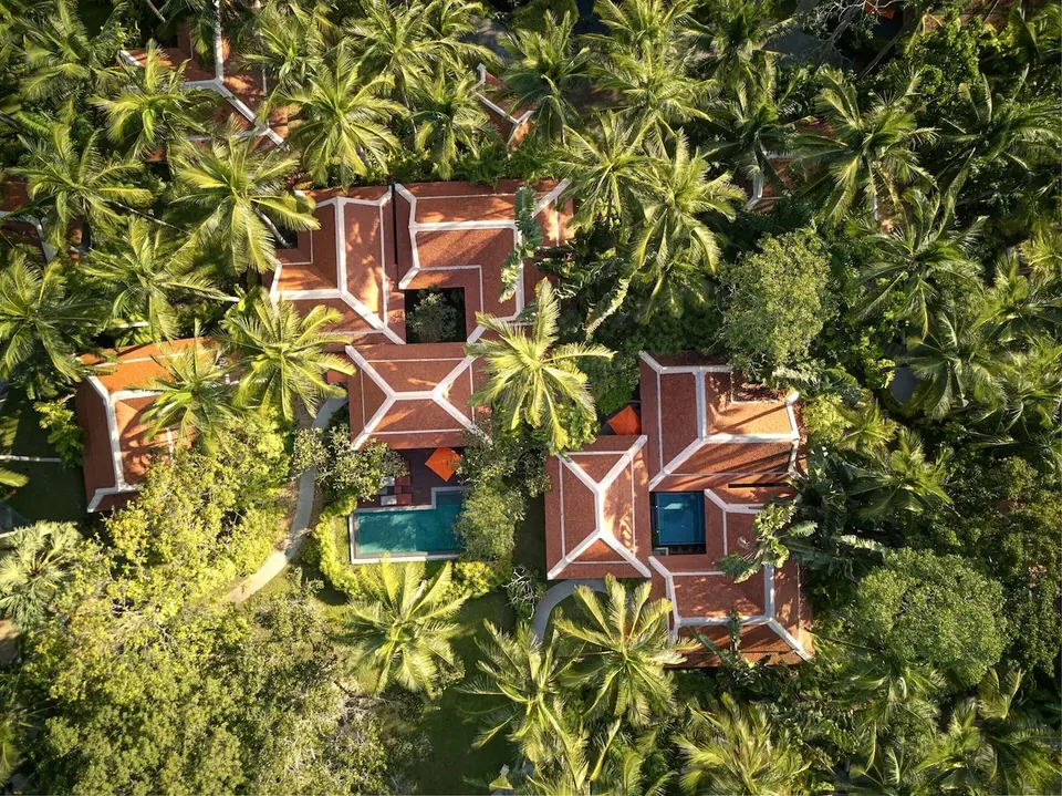 Villaer med pools mellem palmer set ovenfra på Santiburi Koh Samui.