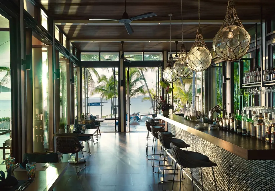 Bar med barstole, hængelamper og udsigt mod havet på Santiburi Koh Samui.