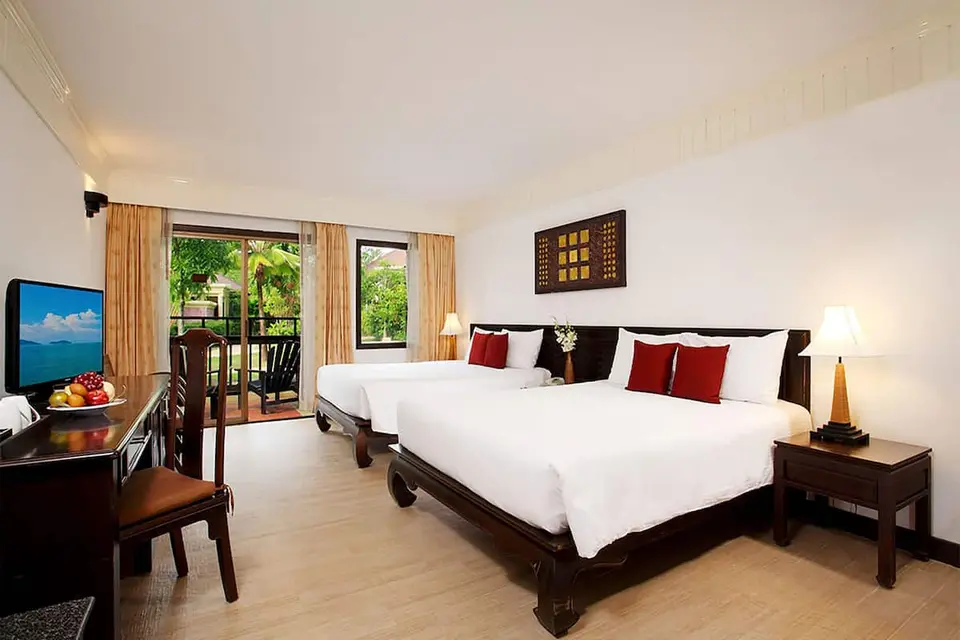Komfortabelt hotelværelse med senge og tv på Seaview Resort i Khao Lak
