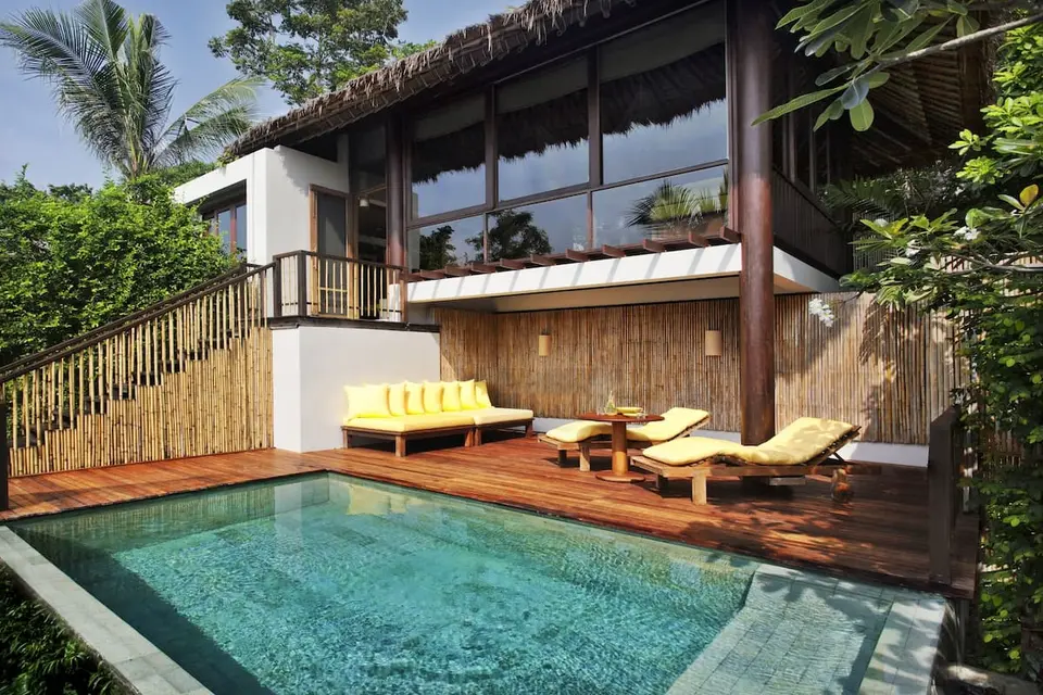 Luxuriøst poolområde med liggestole og træterrasse på Six Senses Samui hotel