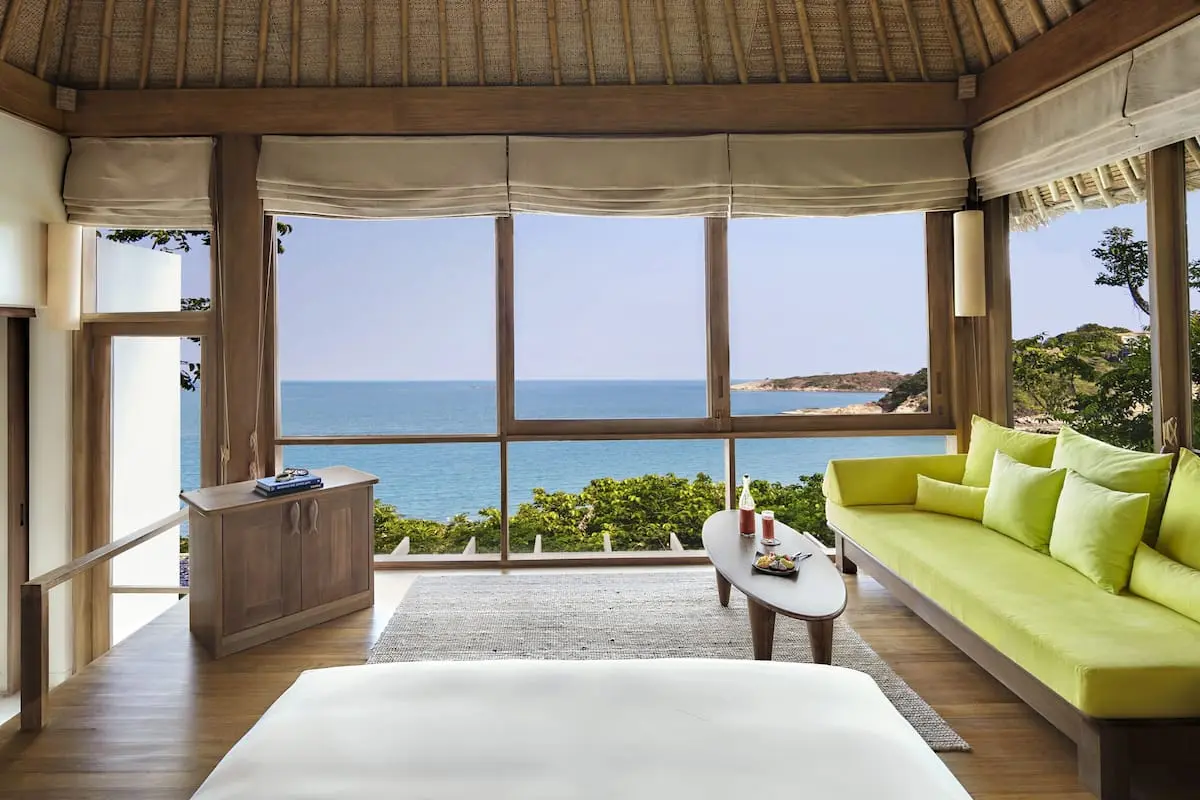 Horisontal udsigt over Six Senses Samui resort værelse med plys seng og panoramaudsigt over havet.